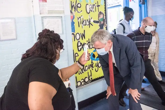 Mayor Bill de Blasio gets his temperature taken by a staffer at P.S. 188 The Island School on September 29th, the first day of in-person learning.